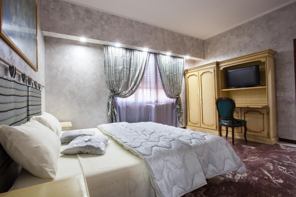 a bedroom with a bed and a desk and a television at Casa Romana in Tor Vergata