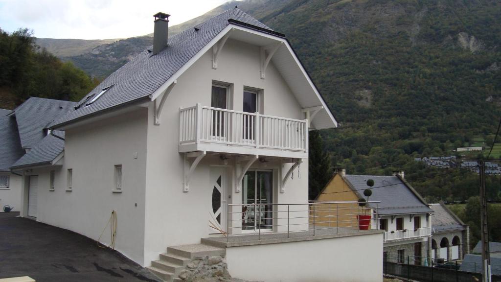uma casa branca com uma varanda em cima em Les coquelicots em Luz-Saint-Sauveur