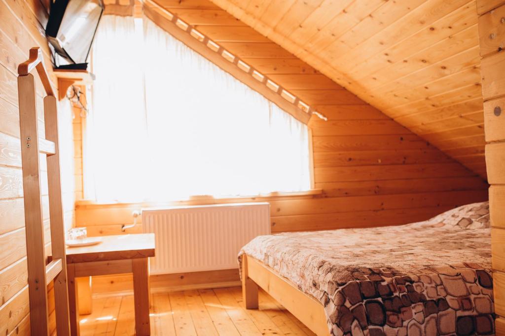 um quarto com uma cama num quarto de madeira em Girskyi Kut em Kuty