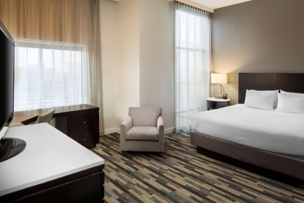 a hotel room with a bed and a chair at Hyatt House Charlotte Center City in Charlotte