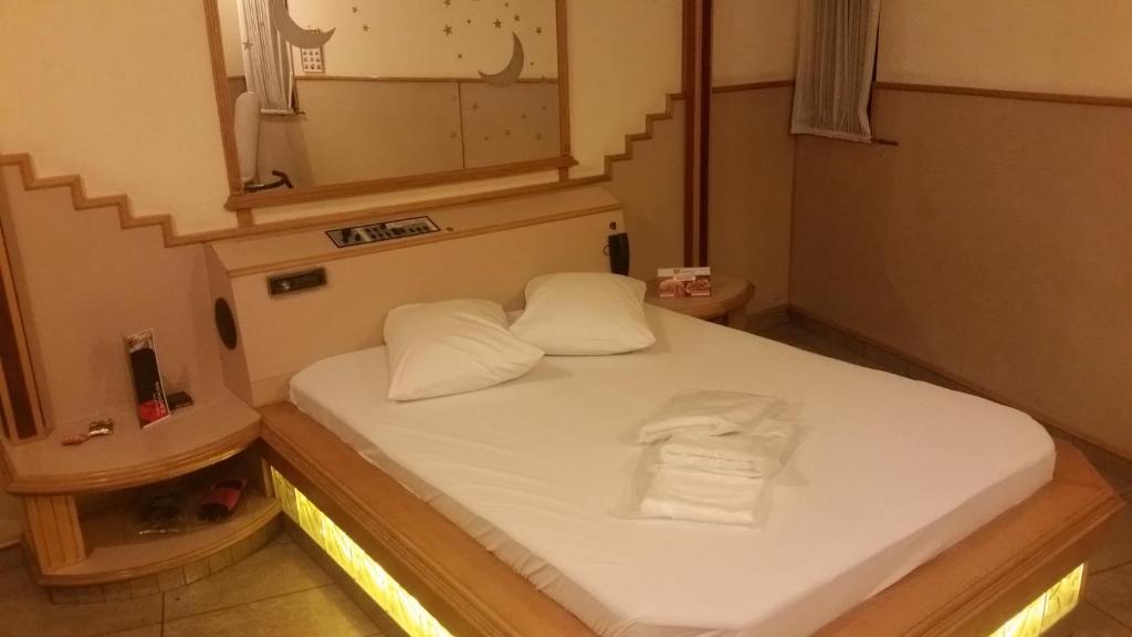 Habitación pequeña con cama y espejo. en America Motel (ADULT ONLY), en Vila Anastácio