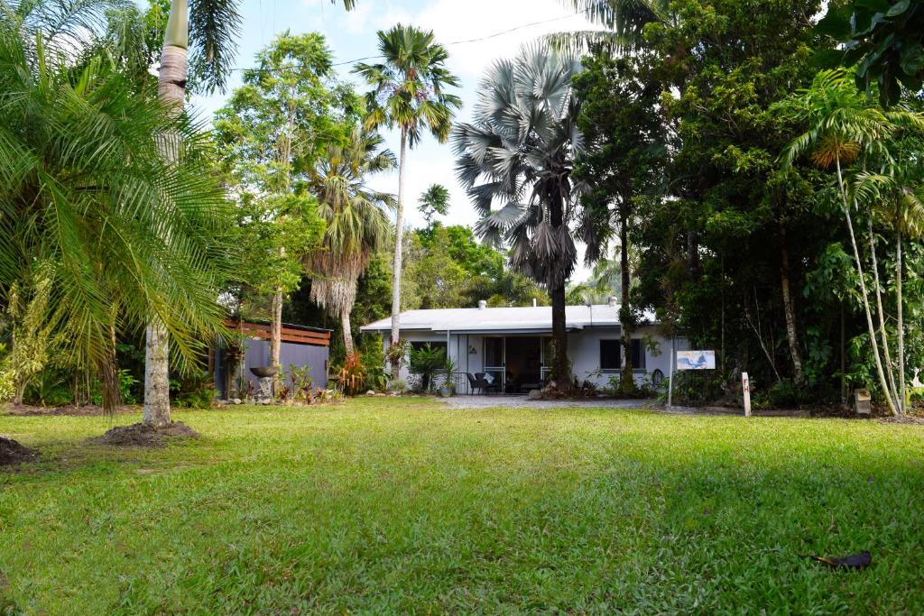 a house in the middle of a yard with palm trees at Egrets Rest in Daintree