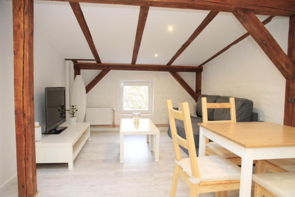 ein Wohnzimmer mit einem Tisch und einem TV in der Unterkunft Gemütliche Dachgeschoßwohnung mit Altbaucharme in Lübeck