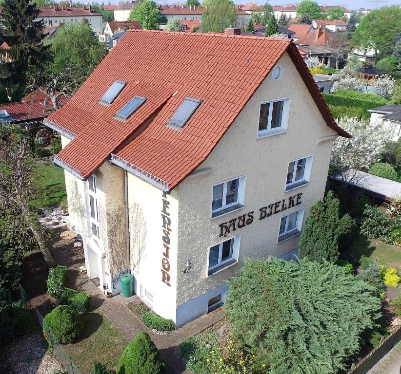 een klein huis met een oranje dak bij Pension Haus Bielke in Berlijn