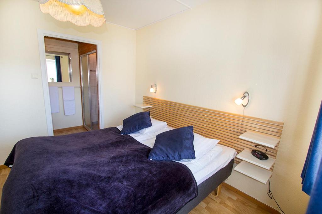 1 dormitorio con 1 cama grande con almohadas azules en Hotel Chaplin, en Landskrona