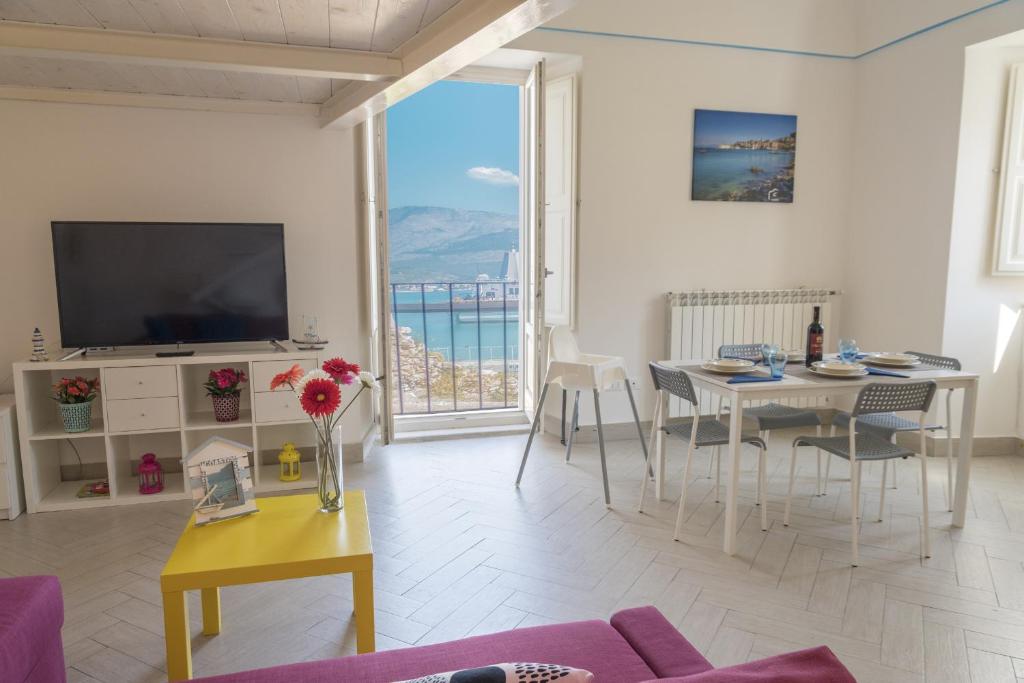 a living room with a table and a large window at Hello Gaeta Apartment in Gaeta