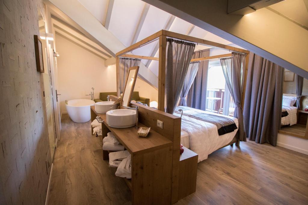 1 dormitorio con 1 cama, 2 lavabos y bañera en Hotel Florida en Levico Terme