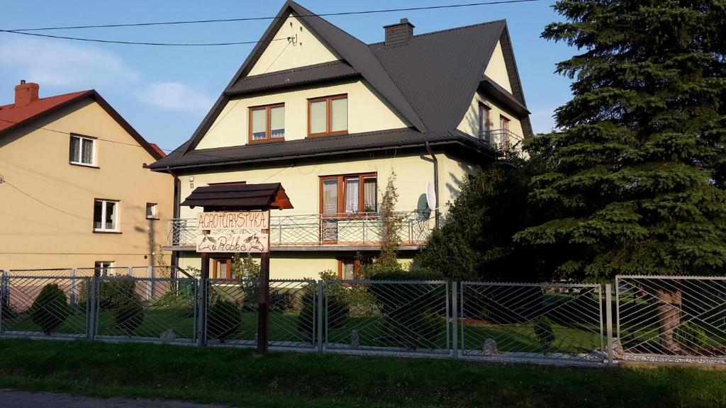 a large yellow house with a black roof at Agroturystyka u Robka in Bodzentyn