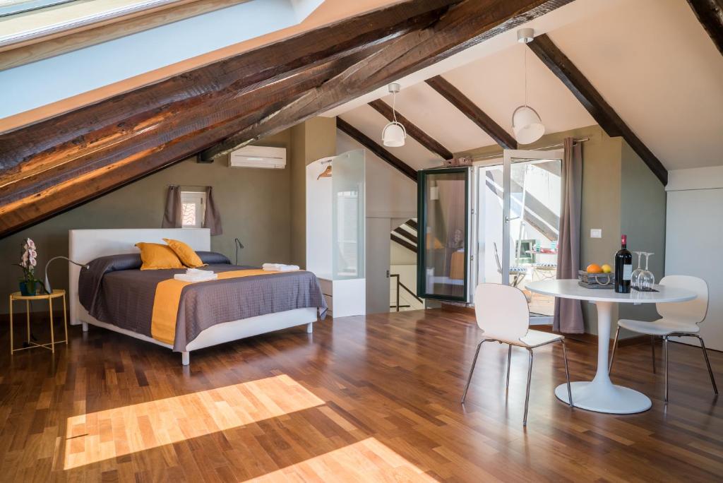 een slaapkamer met een bed, een tafel en stoelen bij Plaium Montis in Salerno