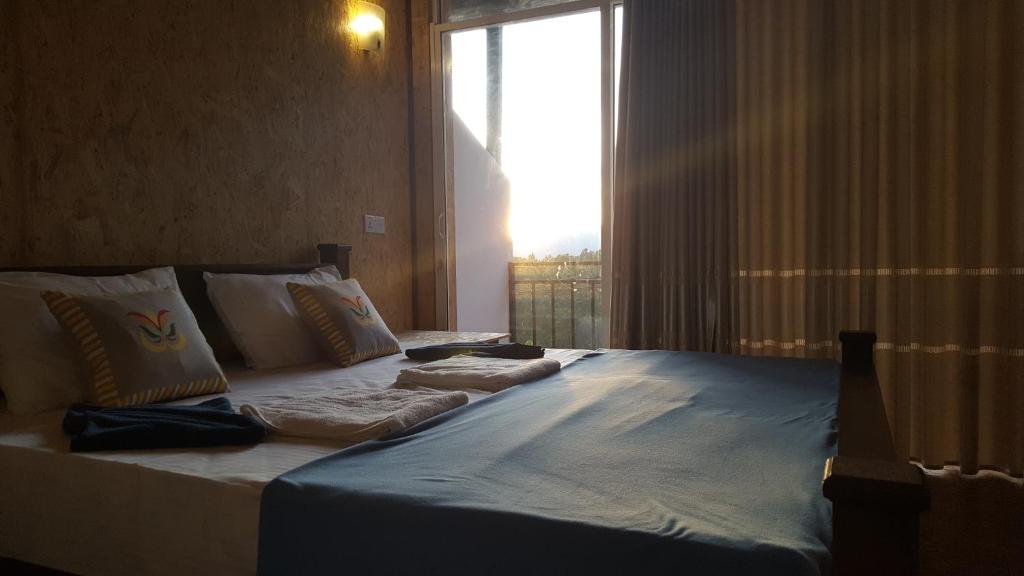 a large bed in a room with a window at Ella Nature Life Guest & Restaurant -Free Pickup from Ella in Ella