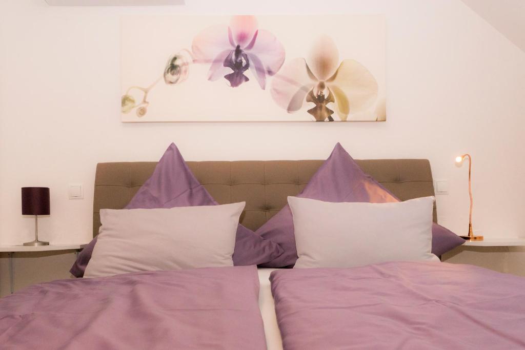 ハンミンケルンにあるPension zum Schlossの紫のシーツと紫と白の枕が備わるベッド1台