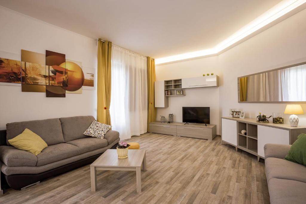 uma sala de estar com um sofá e uma televisão em Residence Hill em San Quirico dʼOrcia