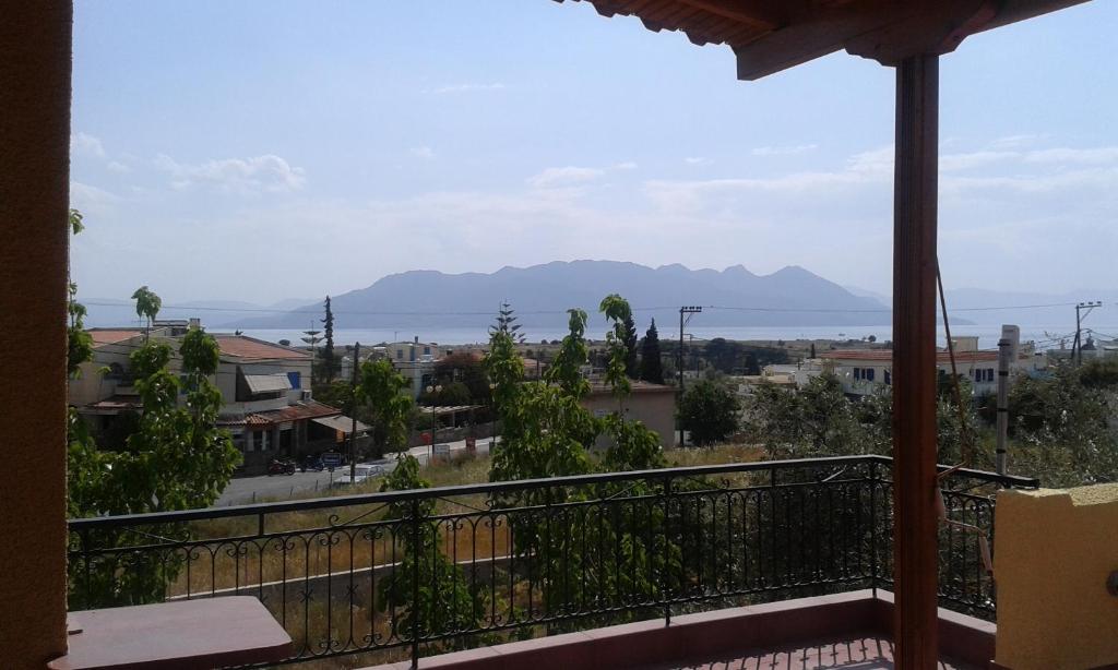 uma varanda com vista para a cidade e para as montanhas em Venetia Studios em Perdika