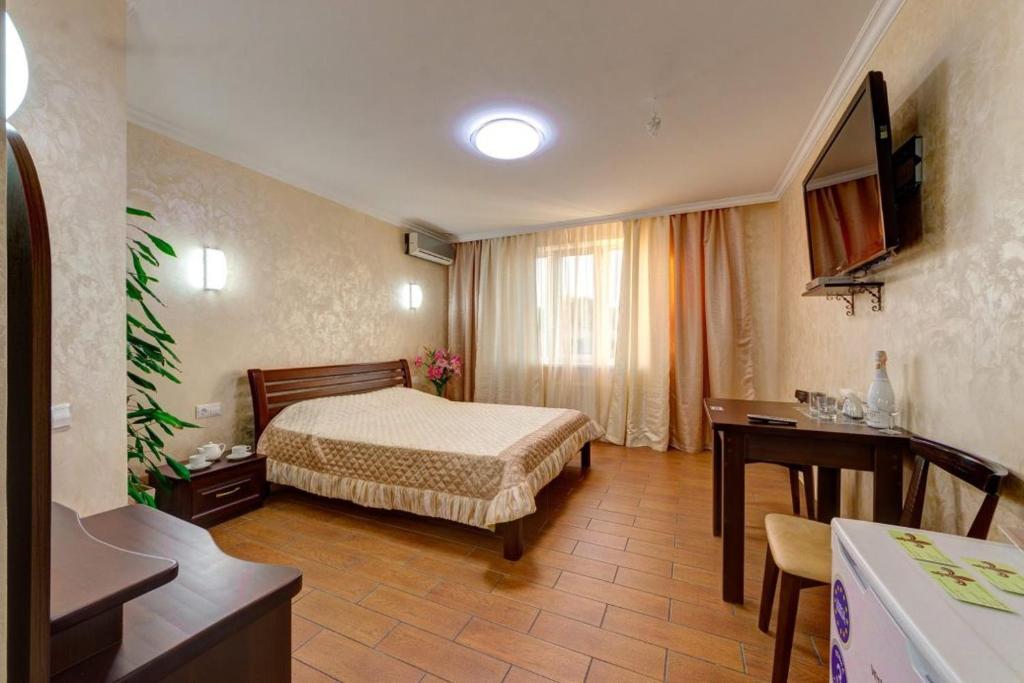 um quarto de hotel com uma cama e uma secretária em Лика Отель em Kiev