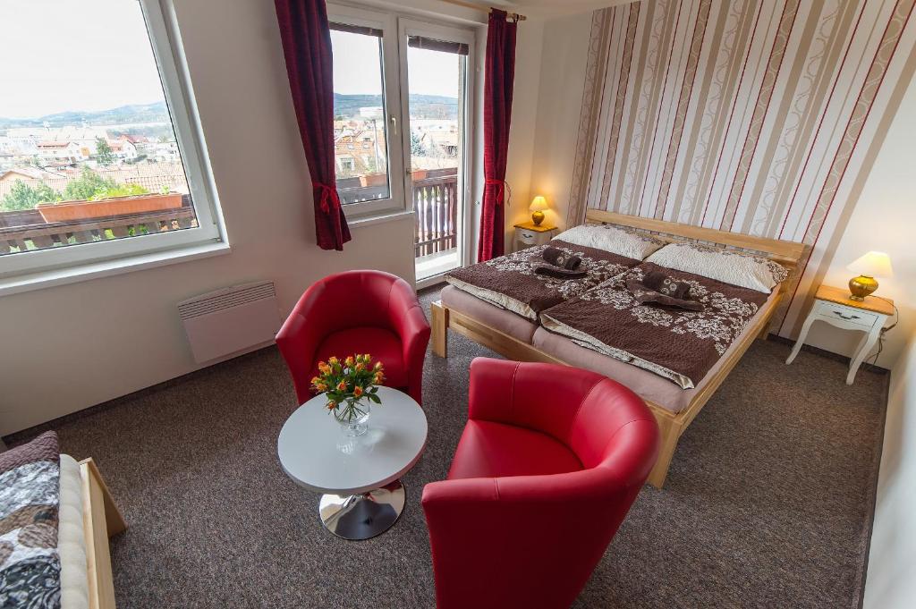 捷克克魯姆洛夫的住宿－拓撲公寓，一间卧室配有一张床和两张红色椅子