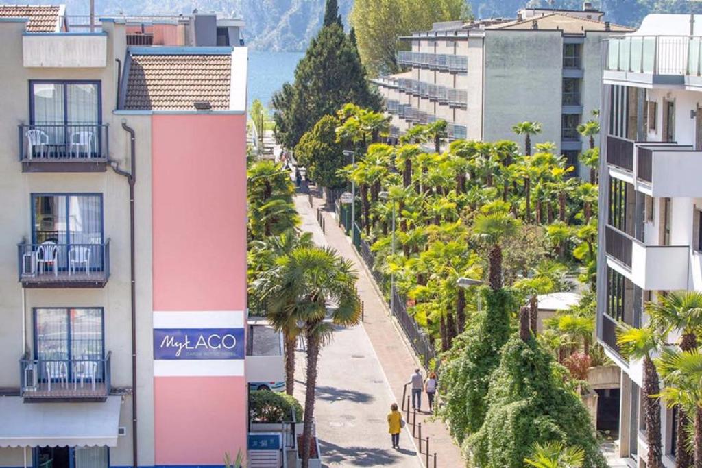 una calle en una ciudad con palmeras y edificios en MyLago Hotel, en Riva del Garda