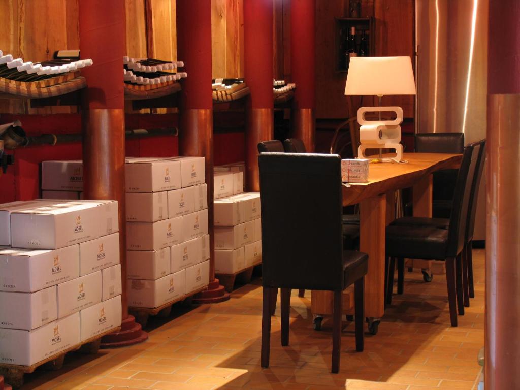 ザンクト・アルデグントにあるWeingut Schumacher - mit privatem Saunabereichのテーブル、椅子、箱が備わる客室です。