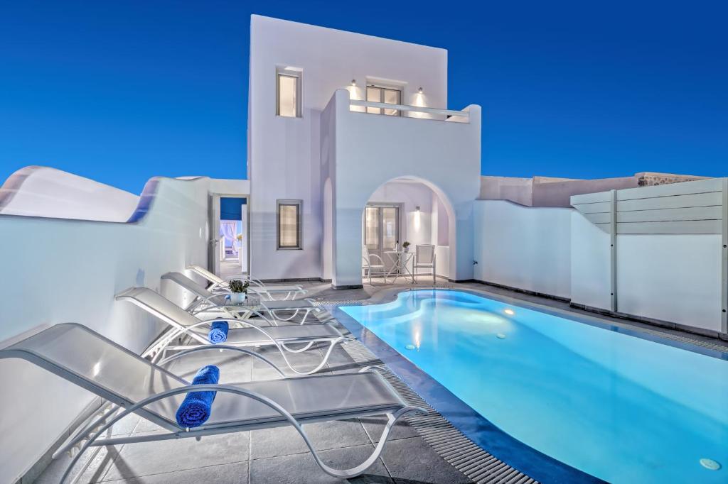 a villa with a swimming pool and chairs at Santorini Blue Senses Villas in Mesaria