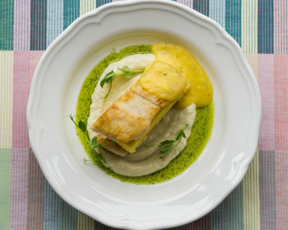 a bowl of green sauce with a piece of fish on top at Nest in Drobeta-Turnu Severin