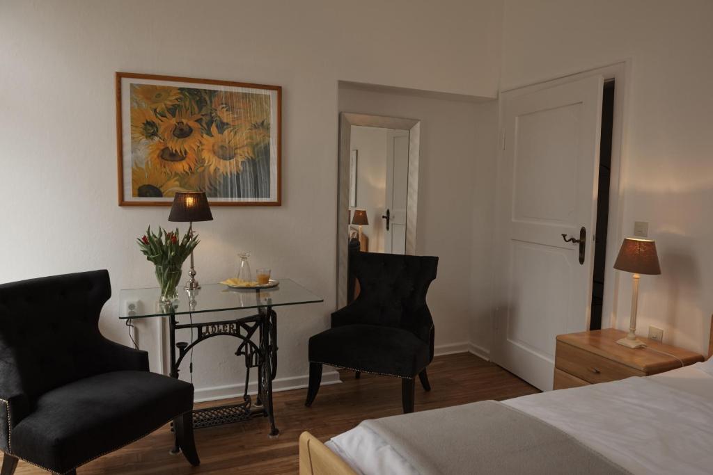 a bedroom with a bed and a table and chairs at Hotel Burgfeld in Kassel