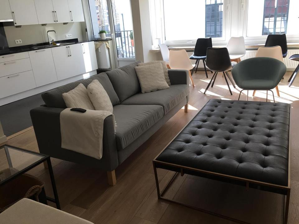 een woonkamer met een bank en een tafel bij Appartement in hartje Gent in Gent