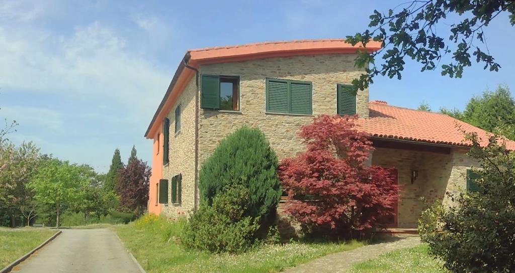 a stone house with green shutters on a road at A xesteira in Santiago de Compostela