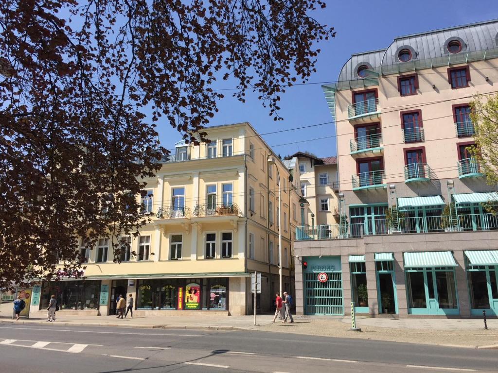 a building on a street with people walking on the sidewalk at Apartmány Dagmar in Mariánské Lázně