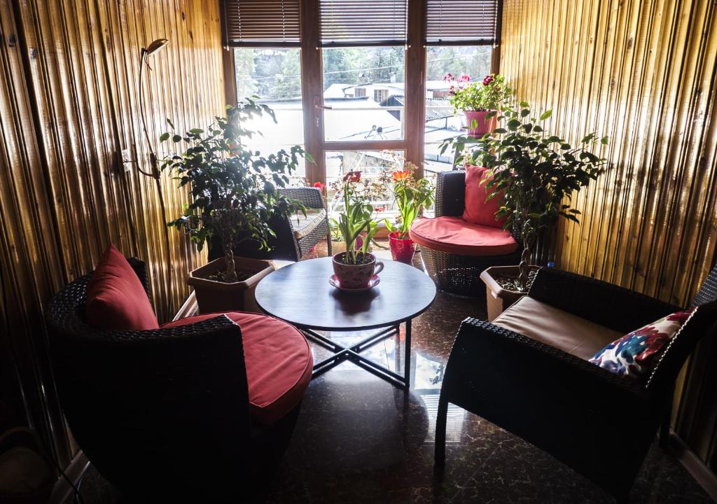 een kamer met stoelen, een tafel en potplanten bij House in Borjomi in Borjomi