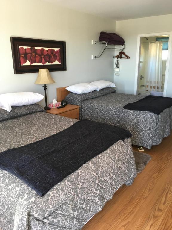 A bed or beds in a room at Anchor Motel and Suites