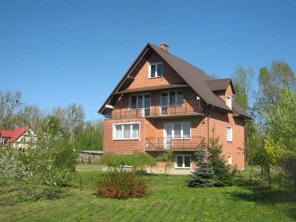 a large brick house with a gambrel roof at Noclegi na Debinie in Gorzyce