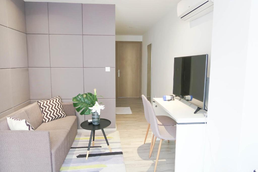 a living room with a couch and a desk with a tv at Comfy Studio 4 by Ong Realty in Singapore