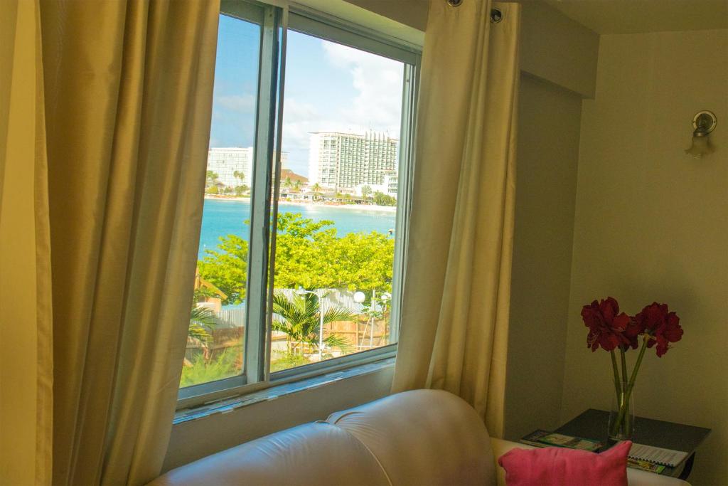 een kamer met een groot raam met uitzicht op de oceaan bij Surf Turf Two Bedroom Suite At Turtle Towers in Ocho Rios