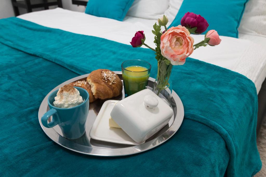 een dienblad met een bord eten en bloemen op een bed bij Palace Residence in Boedapest