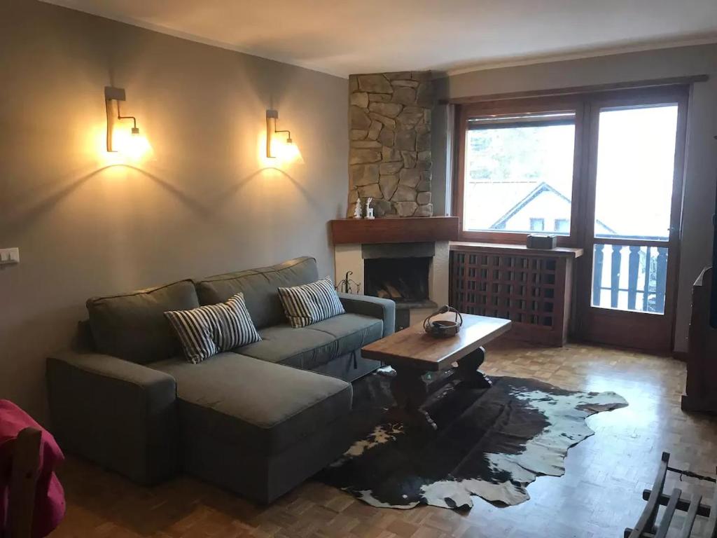 a living room with a couch and a table at Bardonecchia Holidays in Bardonecchia