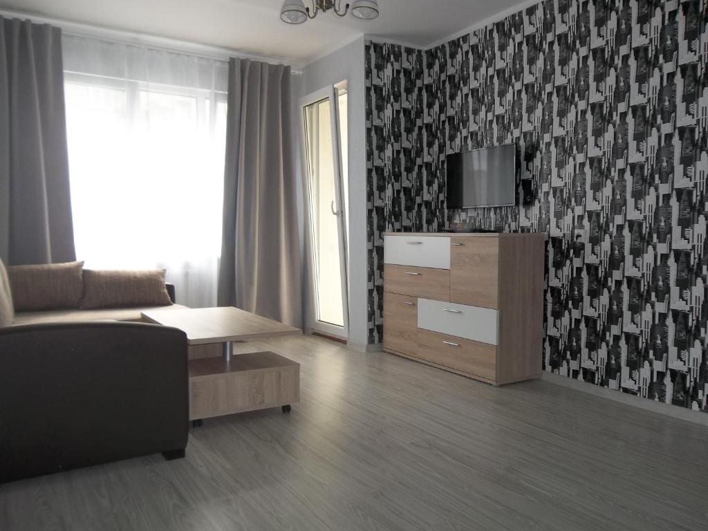 - un salon avec un canapé et une télévision dans l'établissement Sunny Ventspils 3, à Ventspils