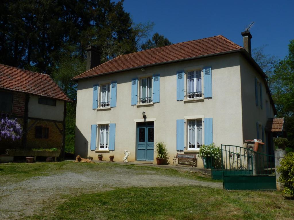 a large white house with blue shutters on it at La Maison d´Amazone in Mont-Disse