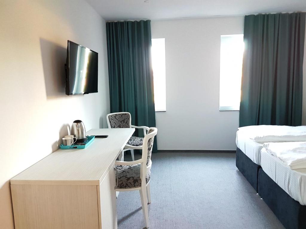 een hotelkamer met een bureau en een bed bij Hotel SAX Gračanica in Gračanica