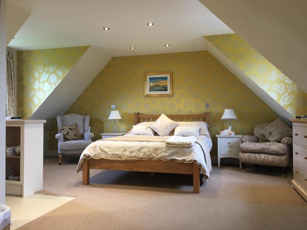 1 dormitorio con 1 cama y 2 sillas en Glen House Annexe, en Bourne