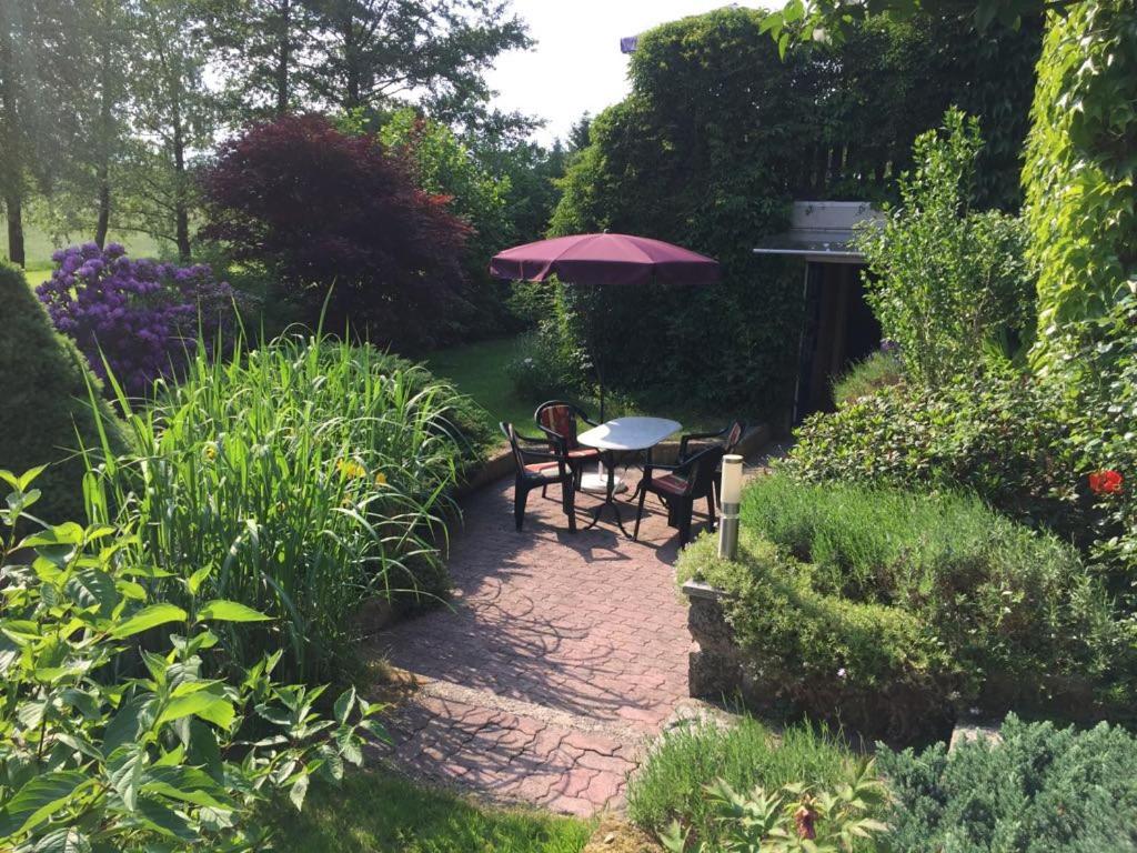 a patio with a table and two chairs and an umbrella at Vogelhaus Rosenthal in Rosenthal