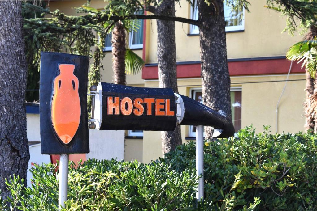 a sign that says hostel in front of trees at Hostel Amfora in Fažana