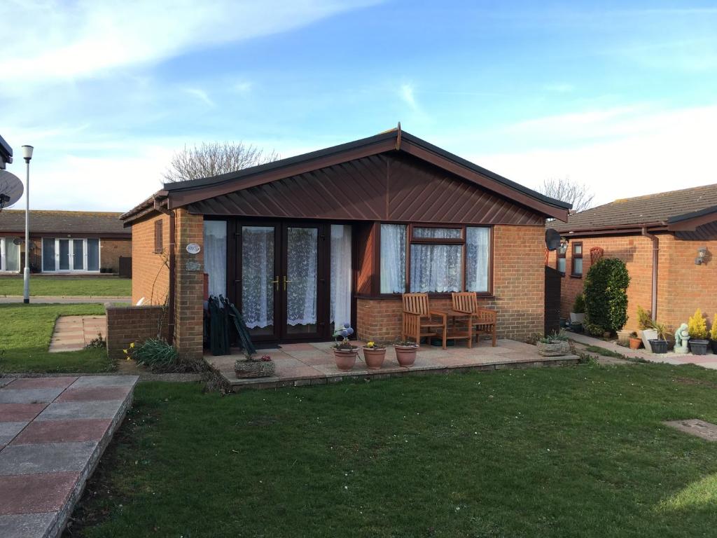 a brick house with a porch with a table and chairs at Dream On in St Margarets at Cliff