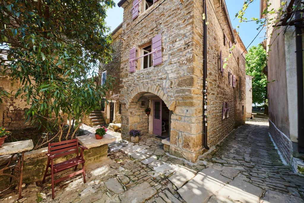 un antiguo edificio de piedra con una puerta púrpura y una mesa en La Boutique en Grožnjan