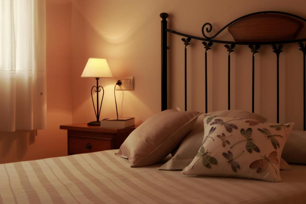 a bedroom with a bed with pillows and a lamp at Casa Toñi in Oia