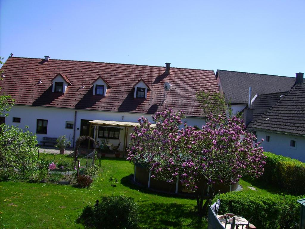 a house with pink flowers in a yard at Gästehaus Brückler in Jennersdorf