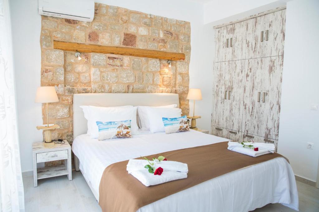 a bedroom with a large bed with towels on it at Haraki Stone Apartments in Haraki
