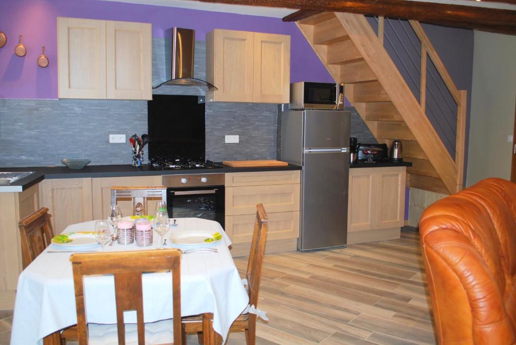 a kitchen with a table with a white table cloth at maison d en haut in Wintzenheim