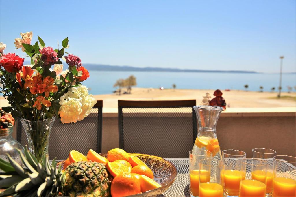 a table with a plate of fruit and orange juice at Apartman Lucita in Split