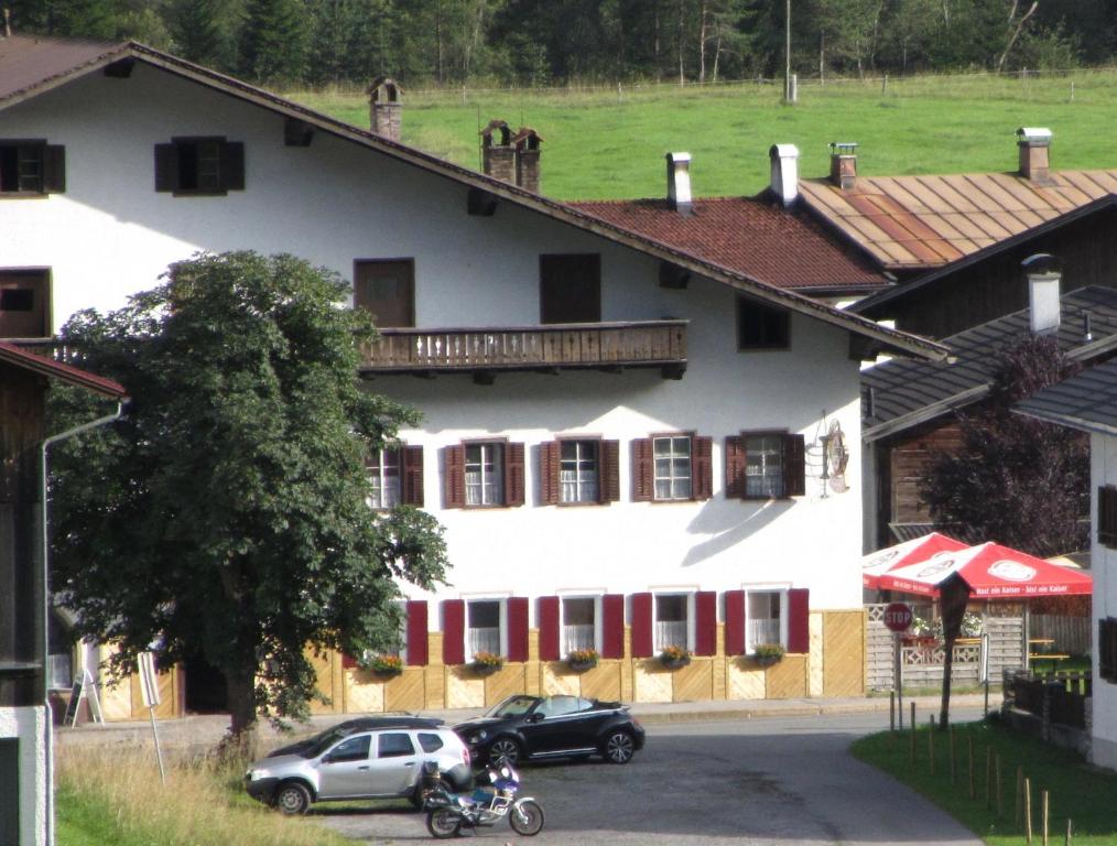 a white building with cars parked in front of it at Gasthof Sonne Häselgehr in Häselgehr