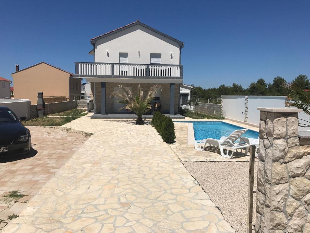 a villa with a swimming pool and a house at Villa Santa Barbara in Vrsi