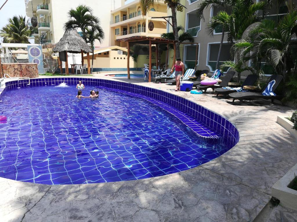 un niño jugando en una piscina de azulejos azules en Hotelito Escondido en Manzanillo